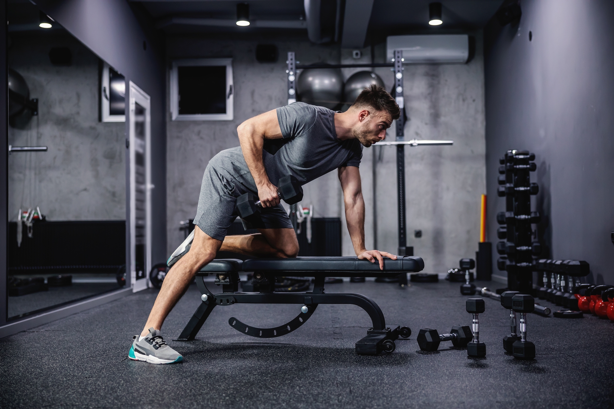 Member performing a dumbbell row in the 24/7 fitness center