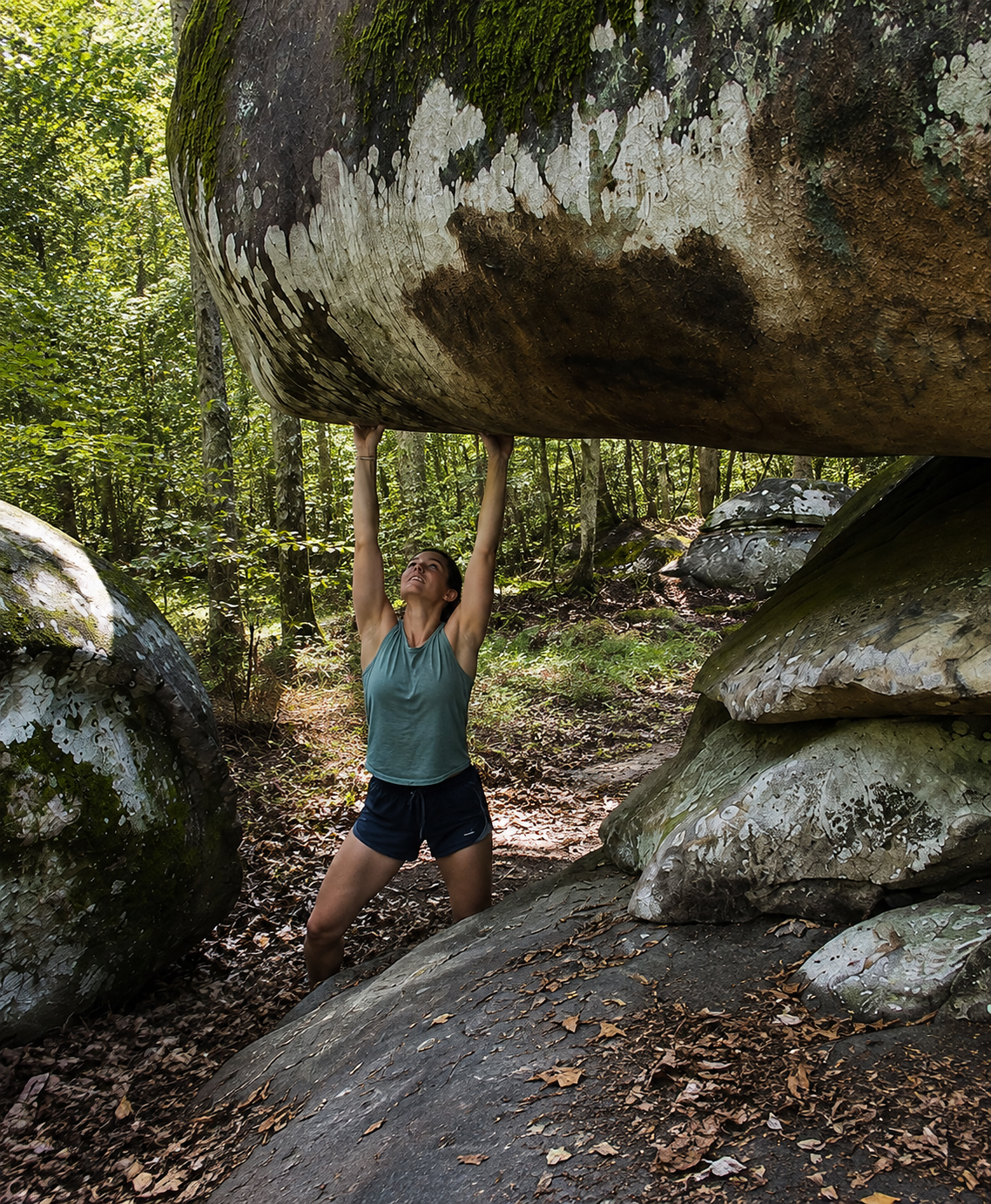 A girl bouldering under Shelter Rock at Shaking Rock Park
