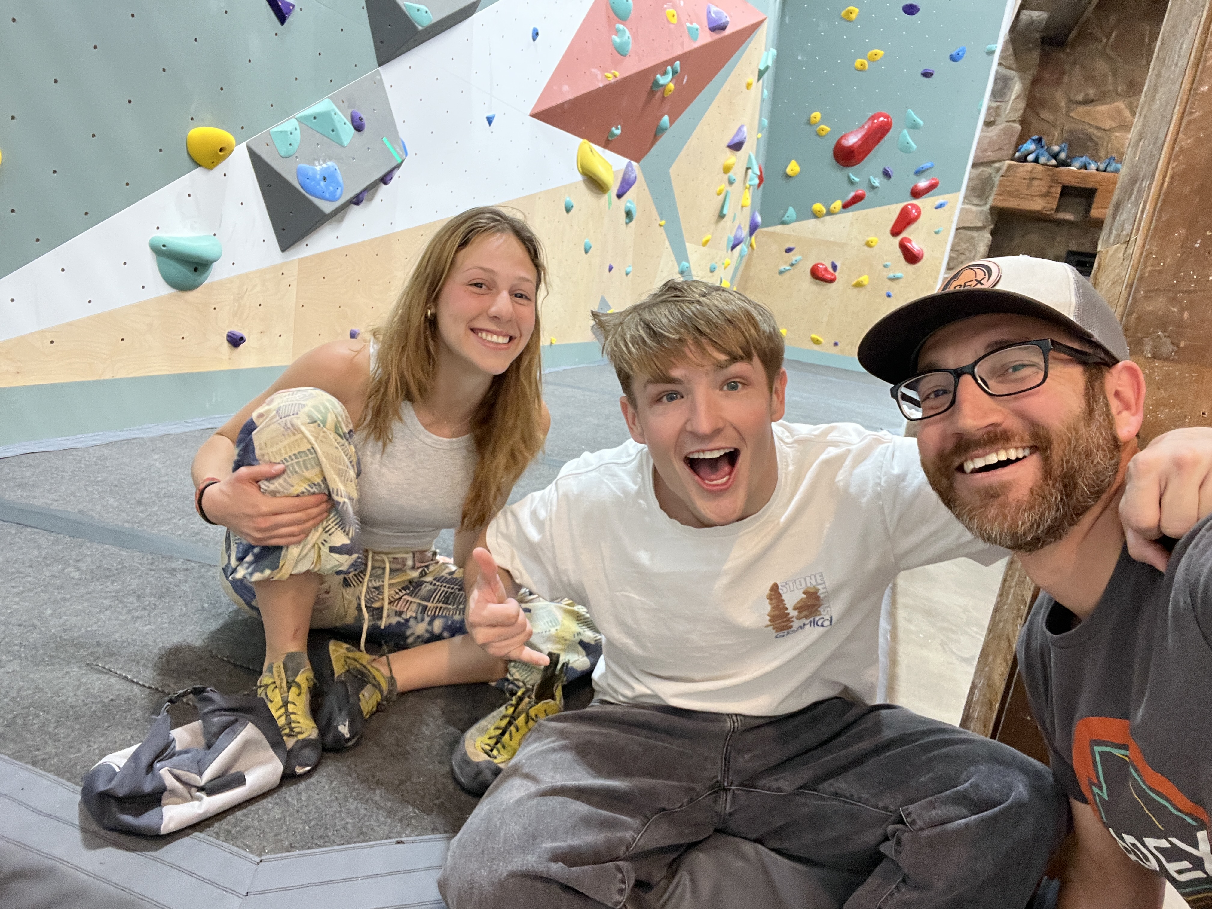 Climber ascending a tall indoor climbing wall at APEX Climbing & Spa