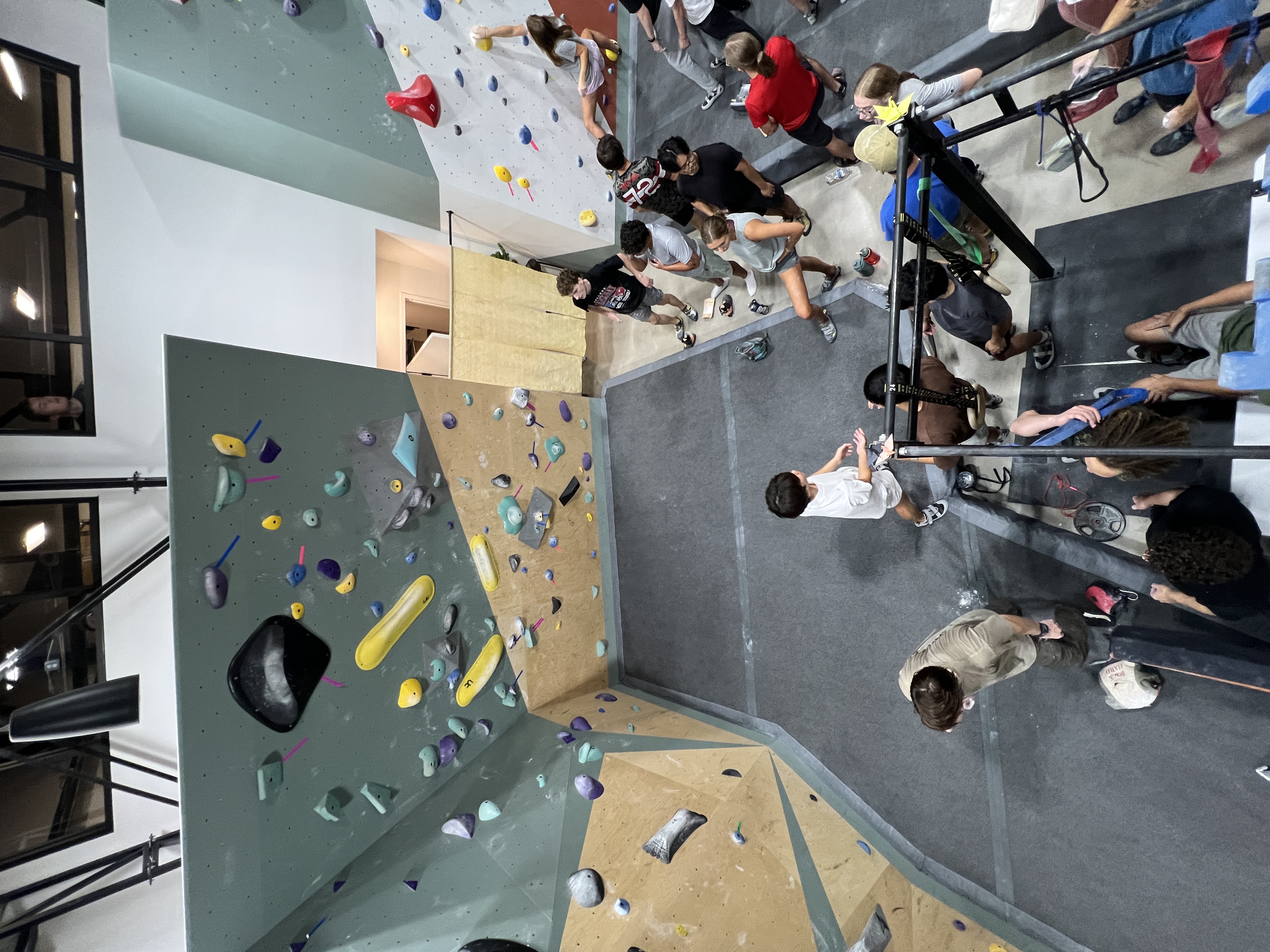 Students spread across the bouldering floor at the APEX Student Welcome Back Party