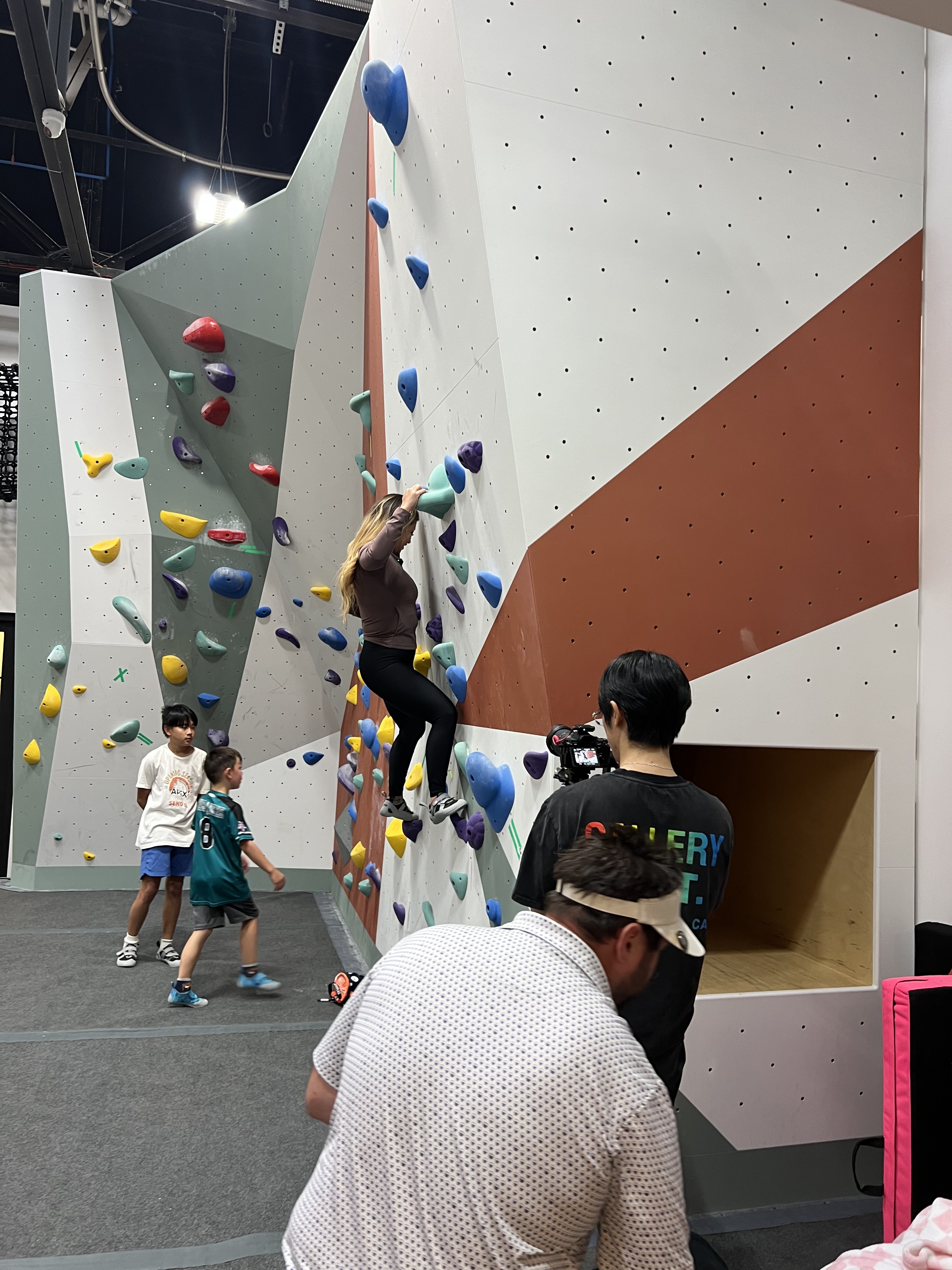 Two laughing girls in harnesses during glow climbing at the APEX Grand Opening